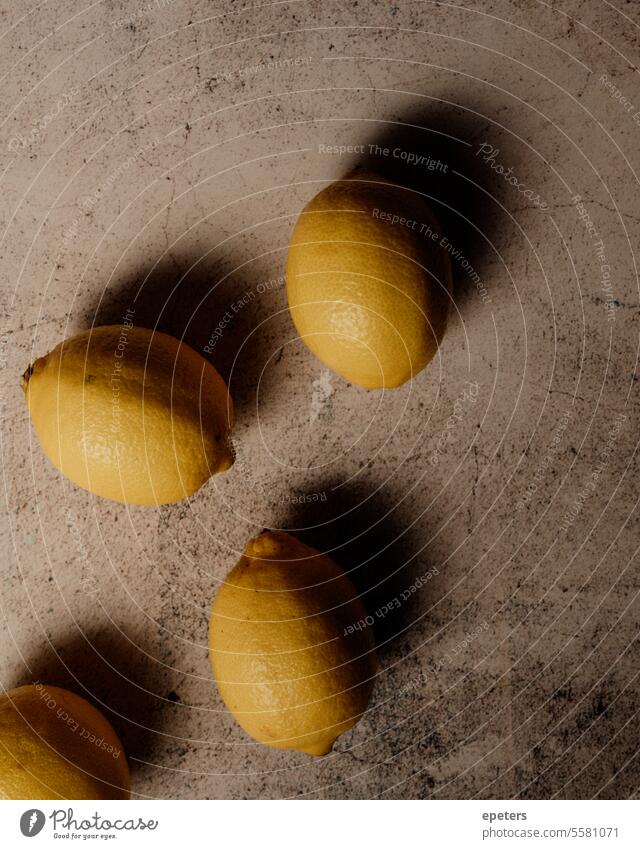 Top-down view of lemons on a textured surface with a moody feel Lemons Textured surface Moody atmosphere Citrus fruits Atmospheric shot Moody lighting