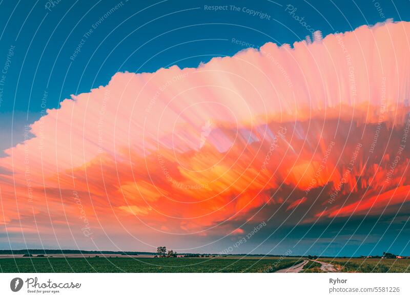 Long Exposure Fasters Clouds Above Countryside Rural Field Landscape. Amazing Effects Of Smeared Clouds. Of Moving Clouds Trails Sky. Sunlight Shining Through Clouds. Sunrays, Sunray, Ray, Dramatic Sky. Magenta Clouds. Pink And Blue Union. Lapse, , . Ab...