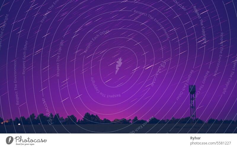 Star Lines Move In Sky Above Rural Landscape. Water Tower In Bac very peri purple magenta serenity galaxy contemplation night sky tranquility outdoor rural