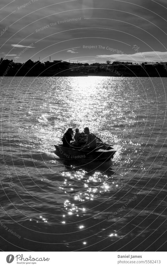 Three people in a small boat silhouetted by a bright sun. Water Harbour Black & white photo Silhouette Watercraft Ocean Exterior shot Reflection Sunlight Bright