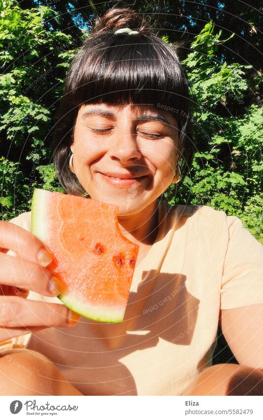 Portrait einer lächelnden Frau mit geschlossenen Augen, die ein Stück Wassermelone hält geschlossene Augen Sommer Sonne Gesicht genießen Essen gesund Obst