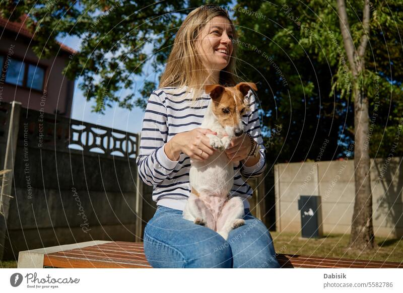 Woman and dog spending time together woman pet owner petting outdoors fun friendship animal hugging love care activity adorable canine caucasian cheerful
