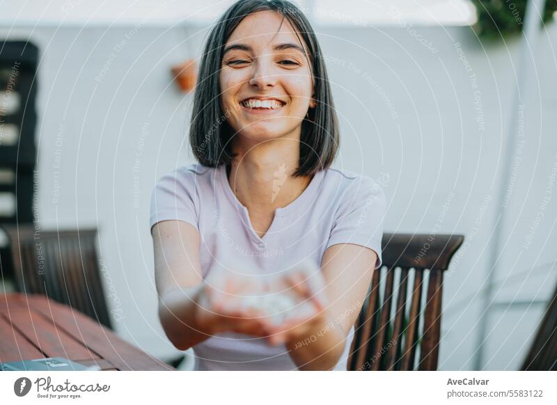 Woman smiling while holding many pills in her open hand, showing it to the camera supplement woman happy painkiller vitamin healthy excited laughing joyful good