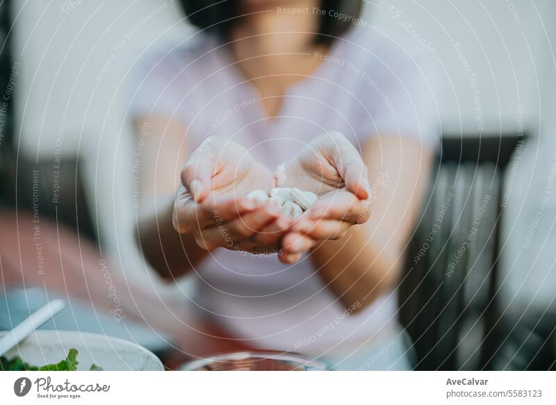 Close up shot of a woman holding many pills in her open hand, showing it to the camera supplement happy painkiller vitamin healthy sharing hope presenting