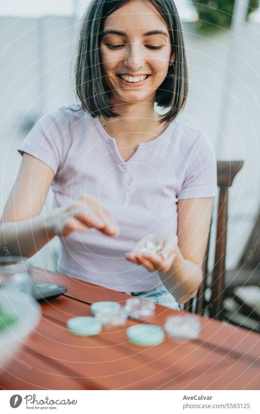 vClose up shot of a woman holding many pills in her open hand, showing it to the camera supplement happy painkiller vitamin healthy smart confident indoor lady