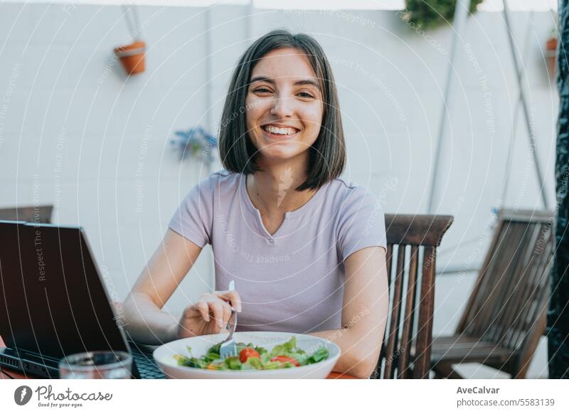Young freelancer woman working on laptop and eating salad, healthy people, working at home concept. pill supplement happy painkiller vitamin fit women indoors