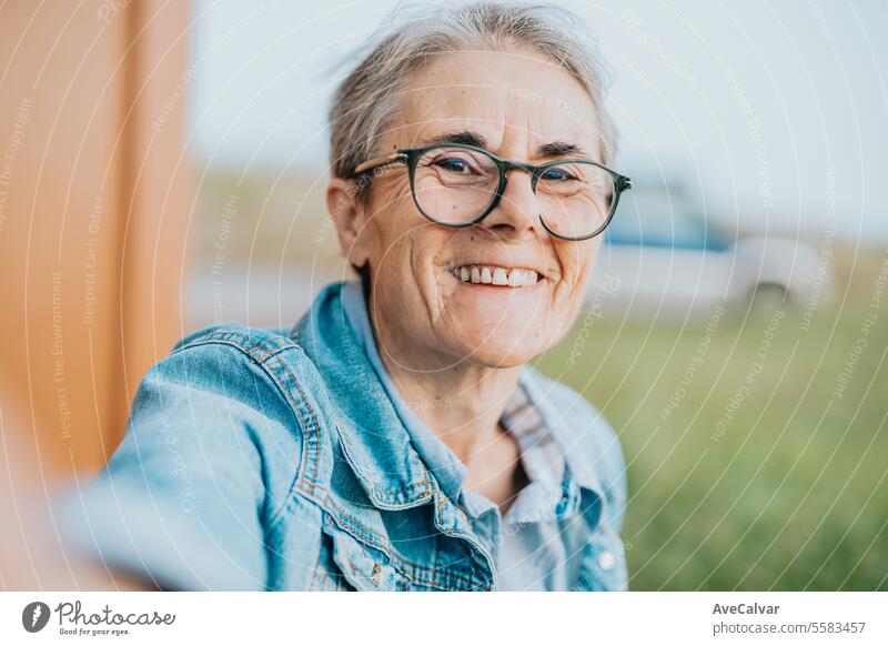 Senior smiling woman taking a selfie while going on a trip after retiring, resting after work. mental retirement person female happy portrait senior mature