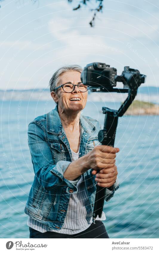 Senior joyful woman recording a video for her family explaining her vacation. Old photographer. streamer live retirement person adult women female lifestyle