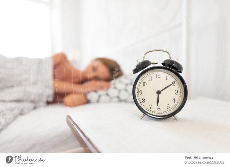 Analog alarm clock. Woman sleeping in bed snooze wake up dreaming day morning time retro analog hands woman young bedroom tired off people life table home