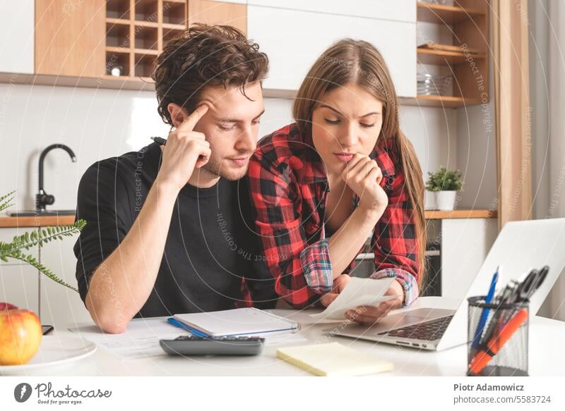 Couple calculating money. Home budget concept home couple finance family payment bill debt people paperwork tax calculate computer financial young house