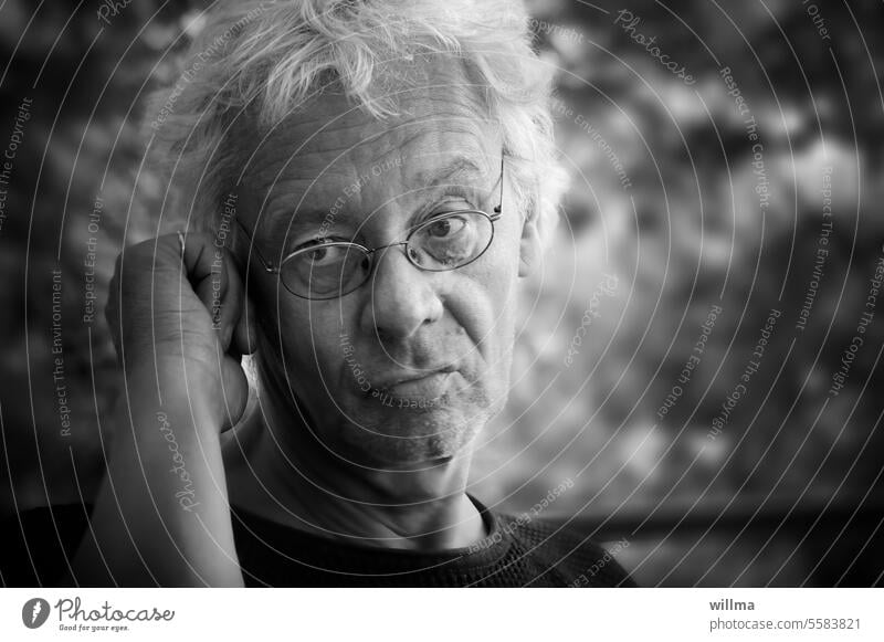 Man with glasses, listening thoughtfully and with a skeptical look portrait Meditative Eyeglasses Skeptical doubting Observe White-haired B/W Gray-haired
