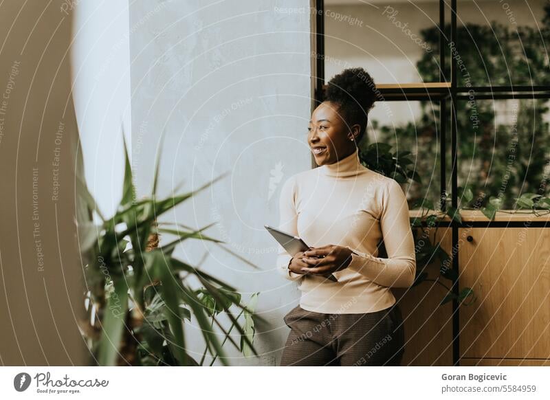 Young African American woman standing with digital tablet at the office african african ethnicity american black business business people businesswoman career