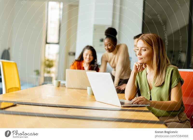Business woman working on laptop with her young multiethnic startup team working in the modern office black african american happy computer casual company