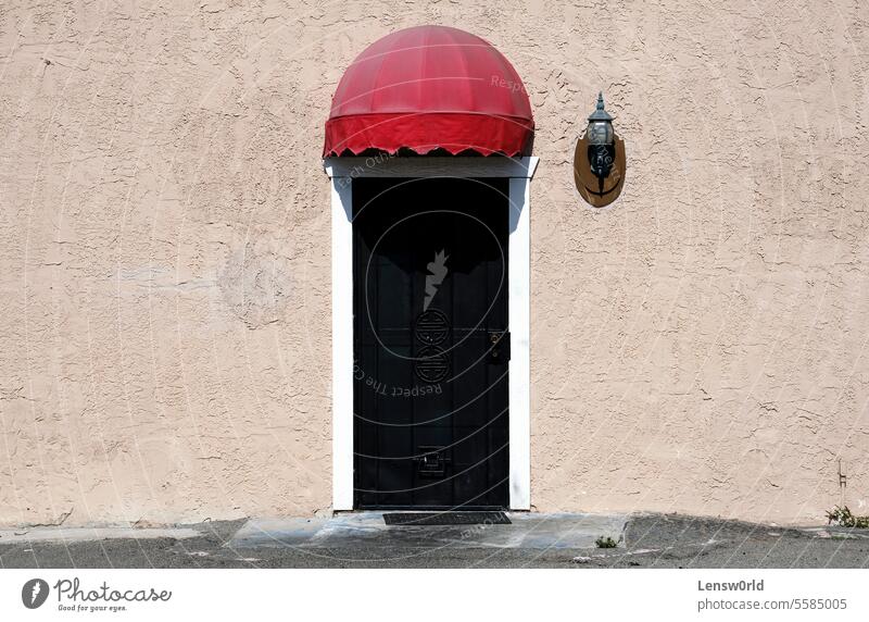 Metal door with little red roof on a sunny day background building city copy space entrance facade house metal outdoors outside wall Facade Wall (building)