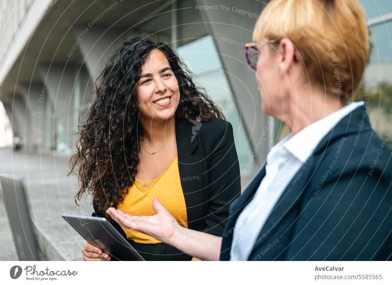 Business people in financial district, diverse colleagues working near office building using laptop outdoors business women person businesswoman female meeting