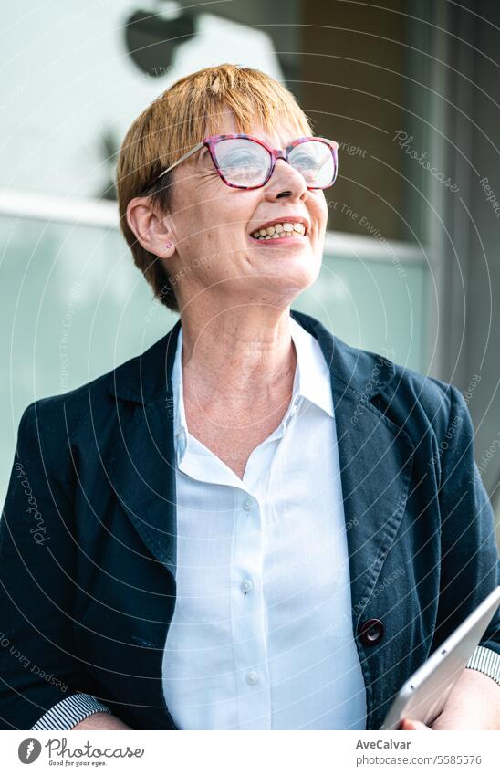 Senior businesswoman in front of a company building happy smiling to camera, woman at business office colleague person women portrait lifestyle female adult