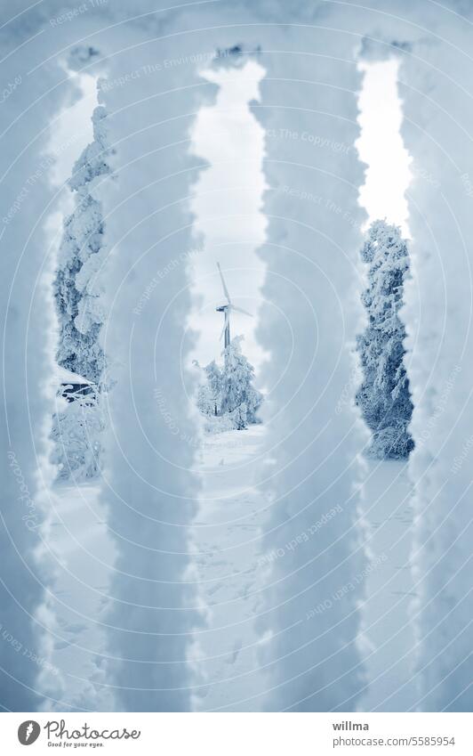View through a snow-covered fence onto a winter landscape with a wind turbine snowy Snow Frost Fence Pinwheel Winter's day Winter mood Snow layer chill