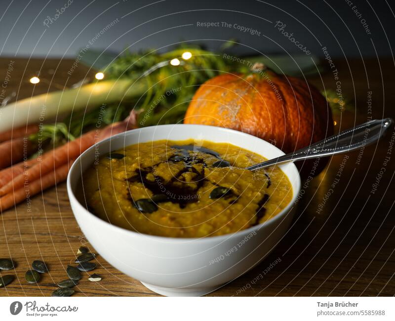 Delicious pumpkin soup in fall with ingredients on a wooden table Pumpkin soup Vegetable Vegetarian diet vegetarian food Nutrition Healthy Eating Thanksgiving