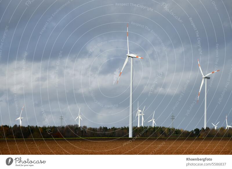 Wind turbine in front of a cloudy sky Wind energy plant Pinwheel wind turbine Windmill Energy Force Environment Electricity Generator Sky renewable green Blue