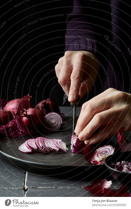 Cutting fresh red onions in the kitchen captured in a moody setting cooking cut cut onions cutting cutting onions dark and moody food photography food styling