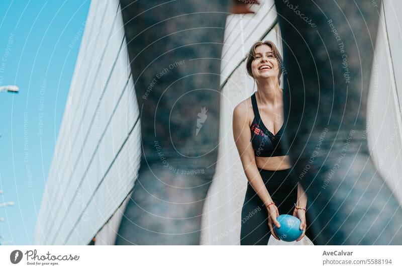 Young girl exercising with a medicine ball to strengthen muscles outside. Healthy and sports life. women female person outdoor urban friends training fitness