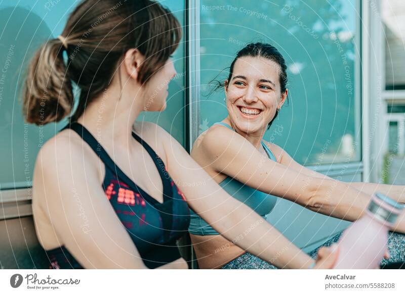 Two young fit cheerful girls sitting rested after doing sports happy to achieve their sports goals. pool women female water lifestyle swim person outdoor urban