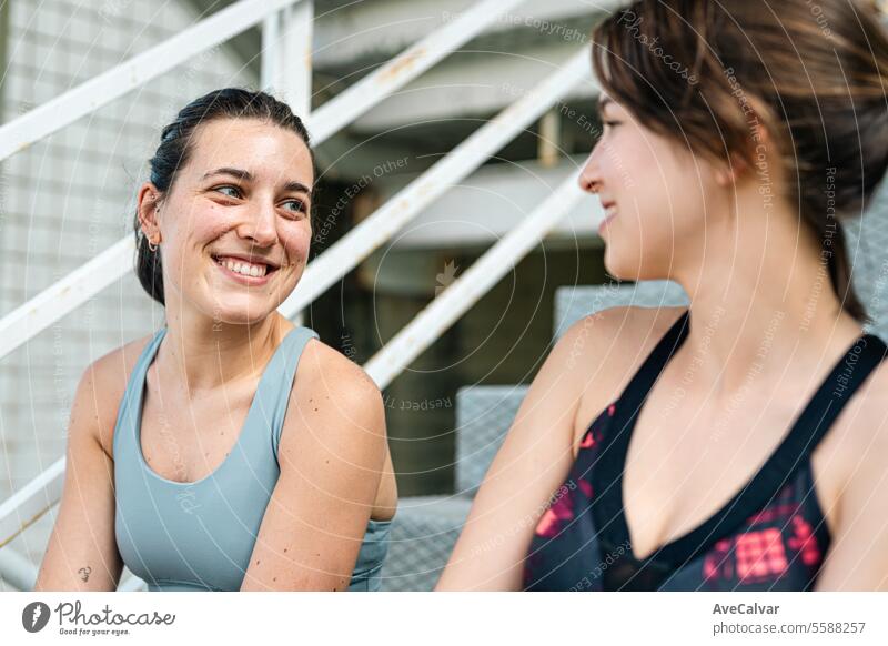 Two women friends talking happily in sportswear ready to do sports together and support each other. lifestyle female beauty young person happy adult outdoor
