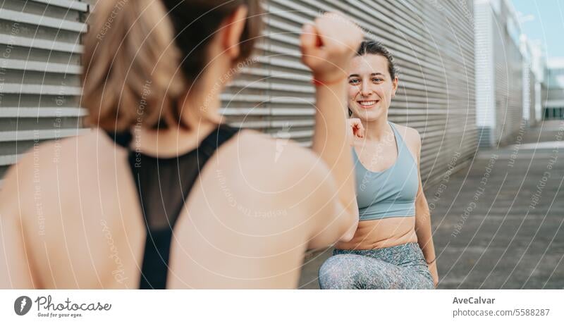 Young woman trainer teaching the different exercises to a student while they exercise with a smile. exercising sport female fit fitness women person adult