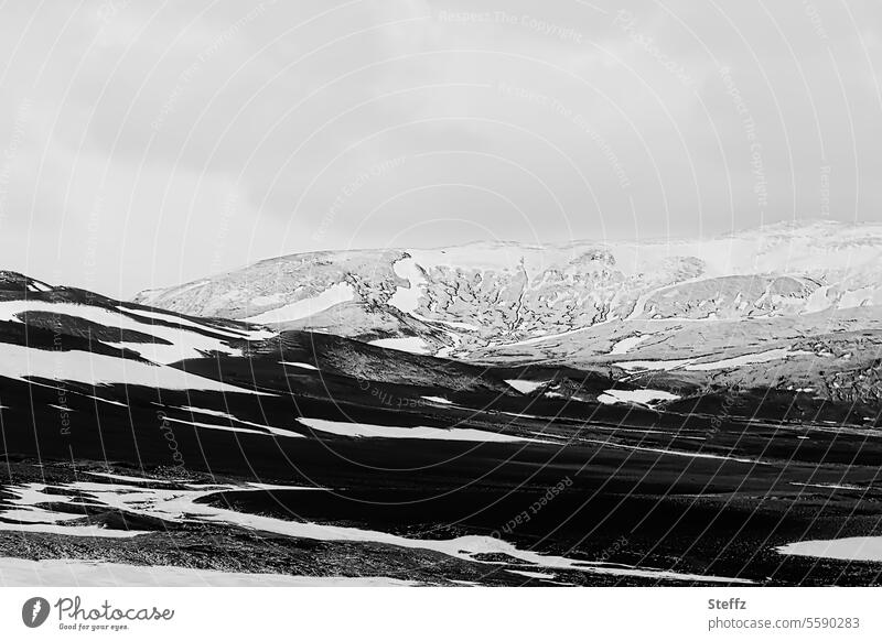 Melting snow in Iceland Hill mountains snow-covered Snow melt Iceland weather snow stains Rock Mountain side Black White Gray iceland trip rocky
