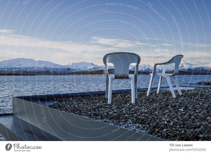 Arctic view Plastic chairs The Arctic Roof Iceberg Snowcapped peak Water Pebble Blue sky outlook Clouds Mountain Norway Winter Winter vacation wide White Gray