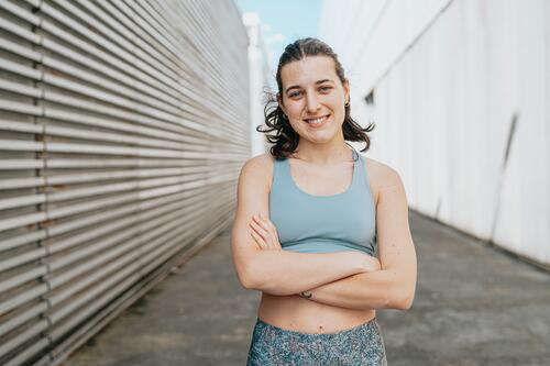 Portrait of a sporty, athletic and exercised smiling woman with her arms crossed in a street setting female beauty model women portrait person young adult happy
