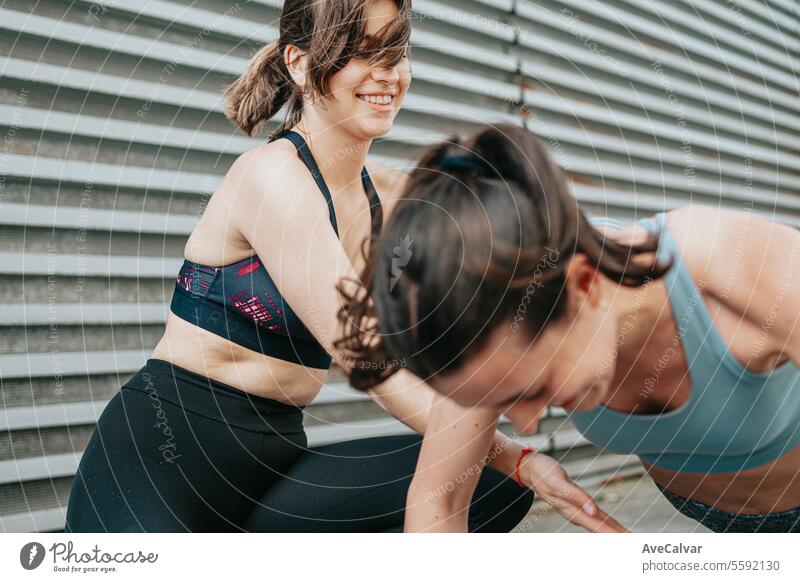 A female trainer teaching a student how to do push-ups correctly.Outdoor sports in urban environment lifestyle fitness exercising person caucasian healthy young