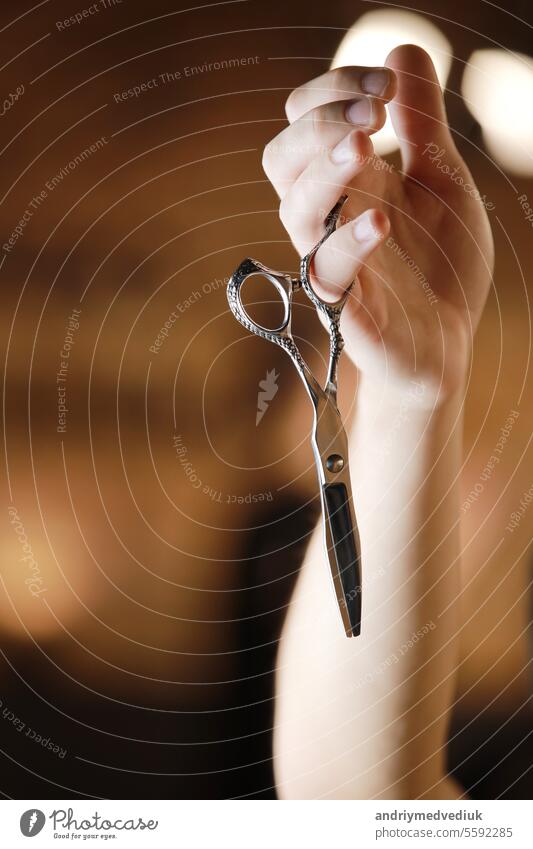 Barbershop. Hairdresser's hand is holding two different type of scissors. Barber professional tools. Male haircut, fashion. Hair salon, haircut and shaving background. Small business. Selective focus