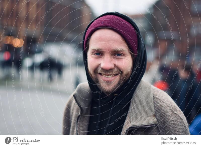 GRIN - CHEERFUL Man 30 - 40 years Facial hair Cap hoodie Cold Grinning Happiness In transit City life youthful Adults Colour photo Exterior shot Contentment