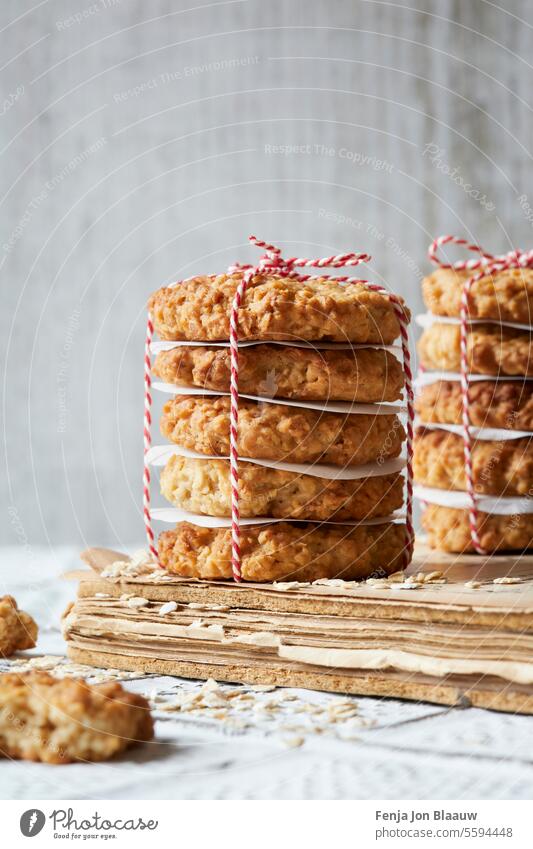 Stack of crunchy home made oatmeal cookies wrapped as a present captured in a bright light moody setting close up food photography food styling healthy macro