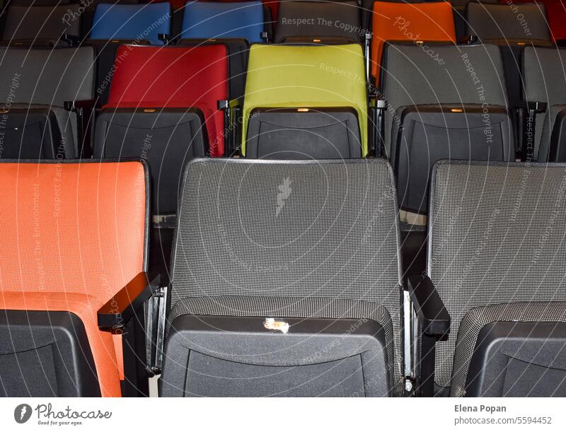 Colored chairs in a movie theatre #chairs #pattern colors similarity difference spectatorship blue yellow orange gray hall