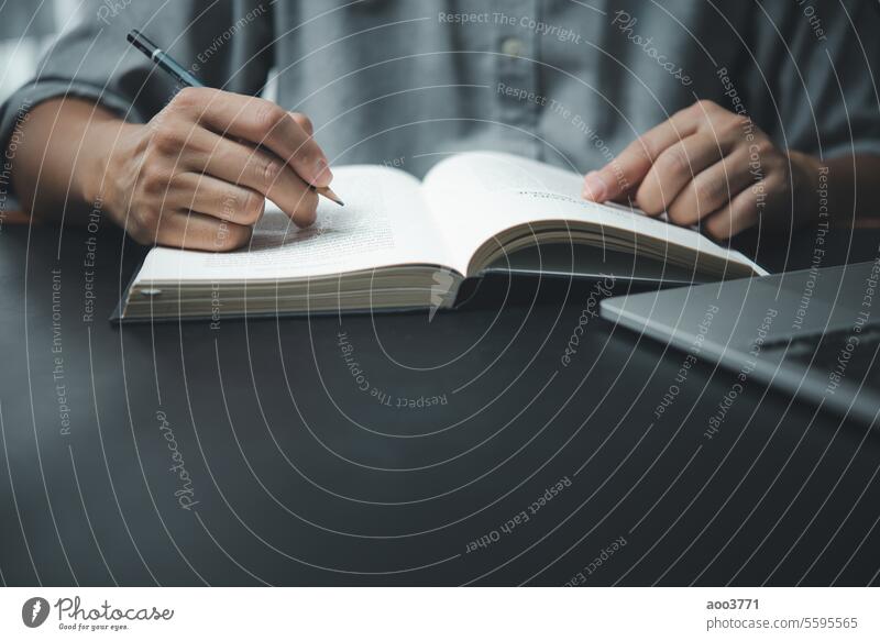 man hands with pen writing on notebook in the office.learning, education and work.writes goals, plans, make to do and wish list on desk. content script