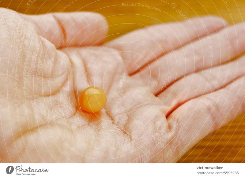 Orange pill in female hand medicine health care orange studio shot medical pharmacy medical occupation copy space colored pill taking medicine one person