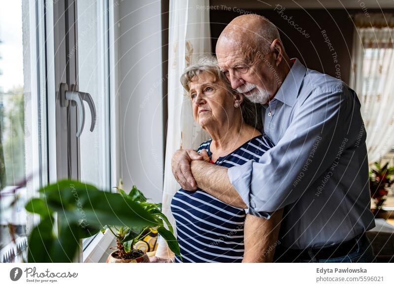 Portrait of senior couple looking out the window at home real people woman mature female together Caucasian elderly house old aging domestic life grandmother