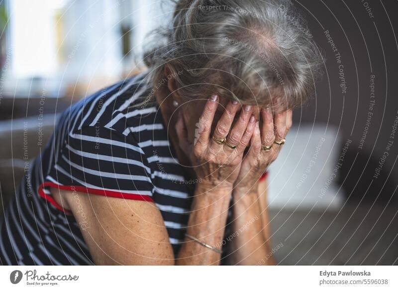 Depressed Senior Woman Covered Her Face With Both Hands nursing home dementia alzheimer geriatrics confused headache depression pain sadness tired distraught