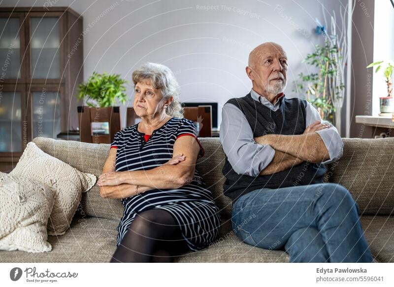 Senior couple sitting on sofa at home having a relationship problems real people woman senior mature female together Caucasian elderly house old aging
