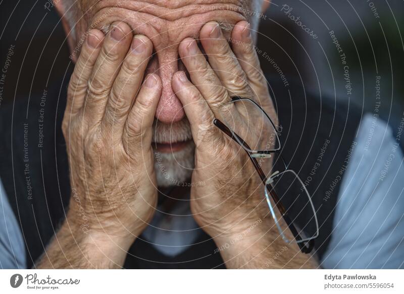Depressed Senior Man Covered His Face With Both Hands real people senior senior adult mature male man Caucasian elderly home house old aging domestic life