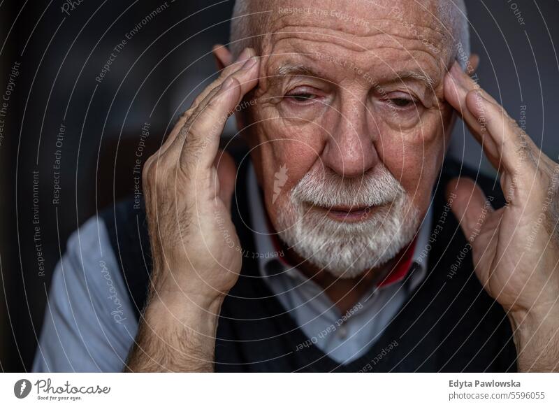 Portrait of a senior man suffering from a headache real people senior adult mature male Caucasian elderly home house old aging domestic life grandfather