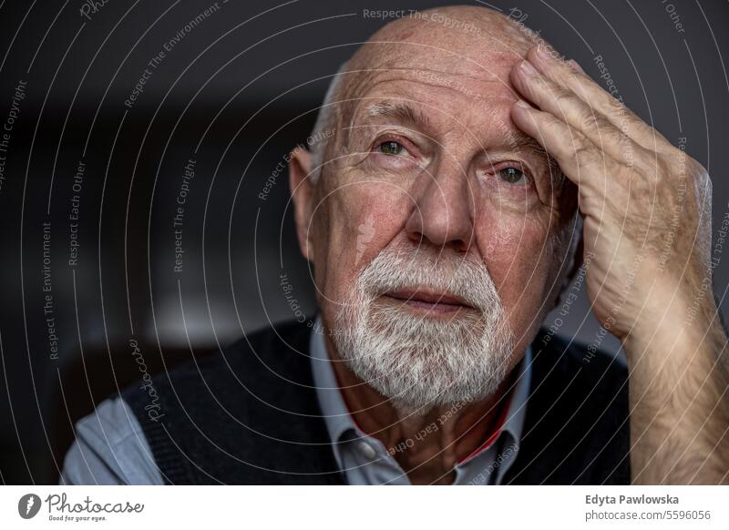 Portrait of a senior man suffering from a headache real people senior adult mature male Caucasian elderly home house old aging domestic life grandfather