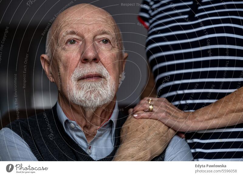 Portrait of a senior man with his caregiver in the background real people senior adult mature male Caucasian elderly home house old aging domestic life
