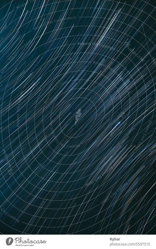 Meteors Trace On Night Dark Blue Sky Background. Spin Of Unusual Amazing Stars Effect In Sky. Abstract Bewitching Illusion Of Star Trails. Soft Colors galaxy