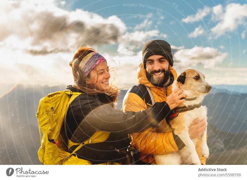 people trekking in the mountains man woman dog couple family hiking sport outdoor petting hike walk active outside backpack vacation smiling happy lifestyle