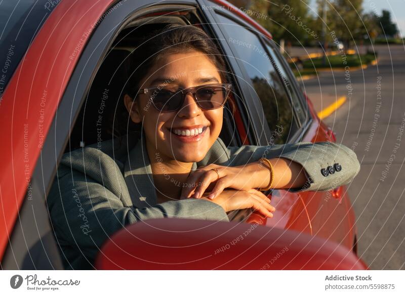 Beautiful businesswoman with sunglasses in car attractive portrait happy young driver blazer orange beautiful looking at camera trip leaning headshot