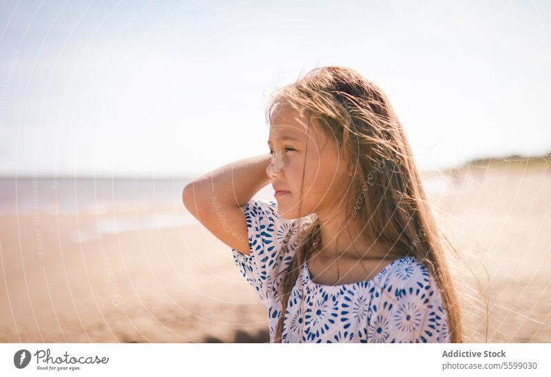 Sunlit contemplation girl profile sunlight hair close-up strand serene thoughtful expression face youth child gaze warmth shadow side beauty innocence day