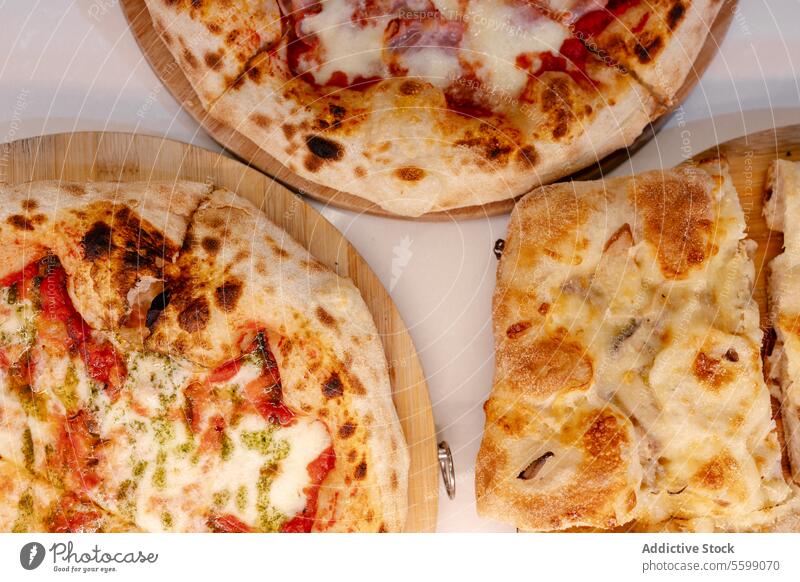 Overhead portrait of several pizzas overhead food italian restaurant dinner ham cheese neapolitan traditional meal delicious oven fresh dough mozzarella cuisine